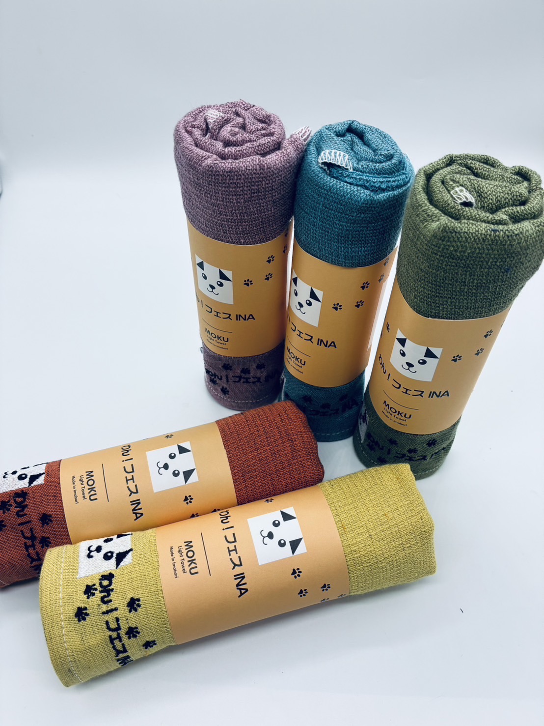 わん！フェスINAの犬のマークと足あとが入った、5色のMOKUタオル。