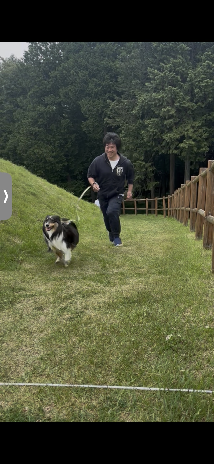 これまでのワンフェスで、芝生のコースを愛犬と一緒に笑顔で走る参加者。